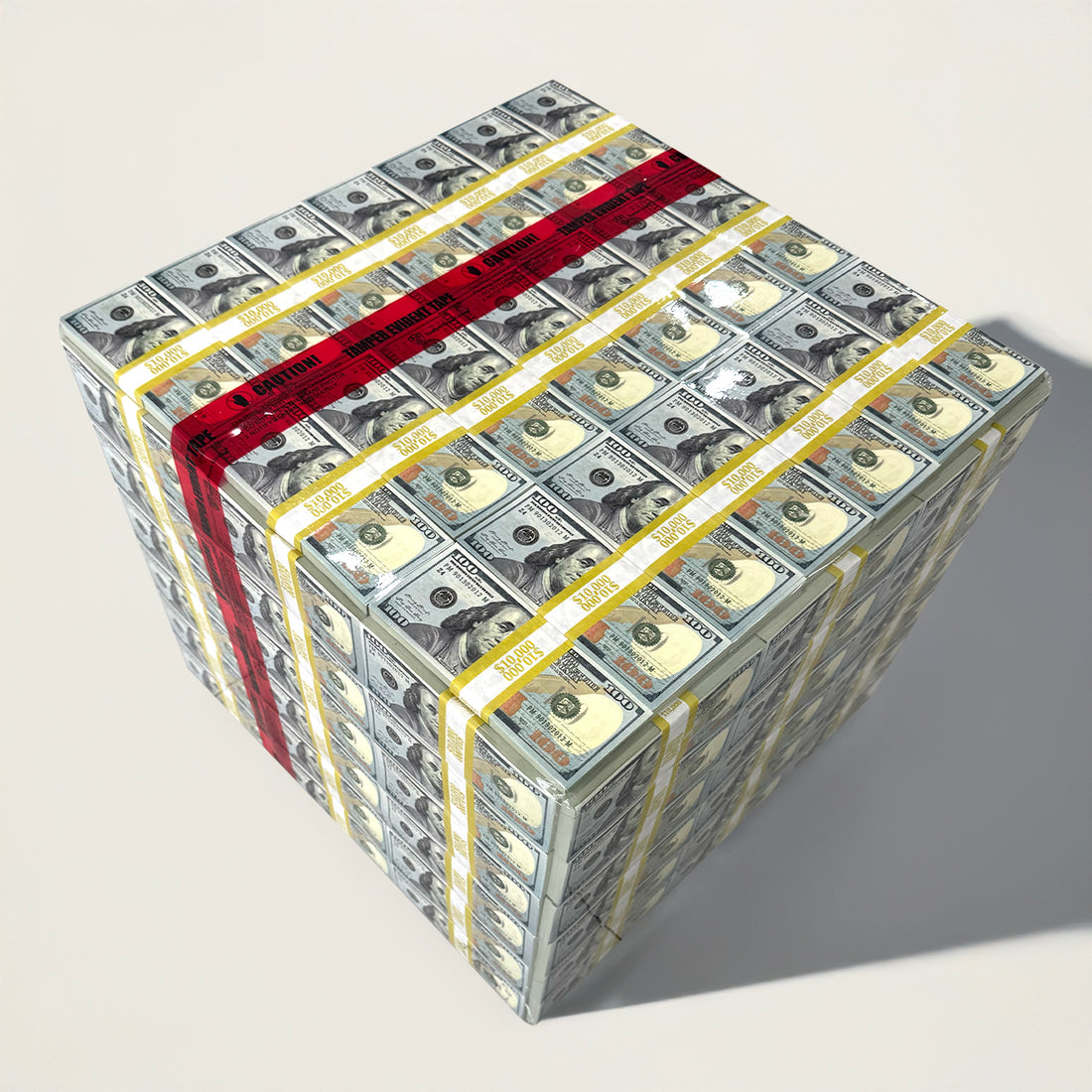 A table designed to resemble a stack of money, with prop bills wrapped in vinyl and accented with red &