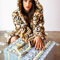 tiger sweater woman starring at money table with prop movie money